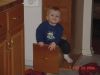 Braydon climbing into cabinet.JPG